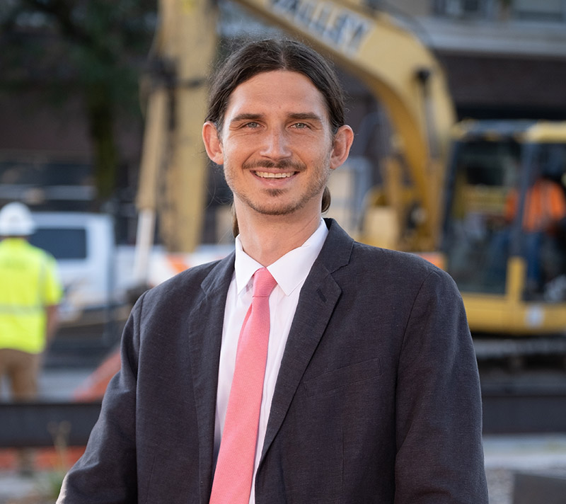 Headshot of Dylan Parker in front of construction equipment